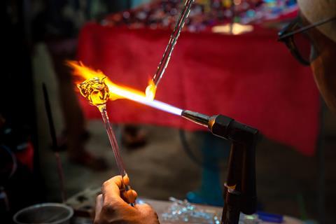 Glassblower made handicraft from melted glass roses shaped at the end of glassblowing pipe