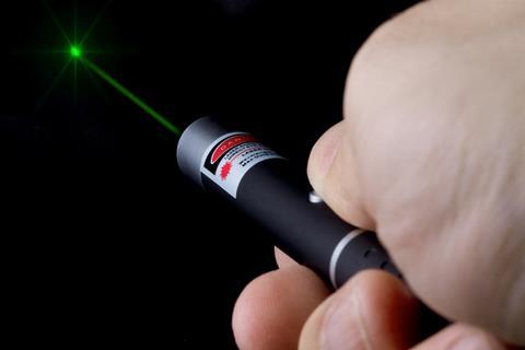 Hand holding a high power green laser pen