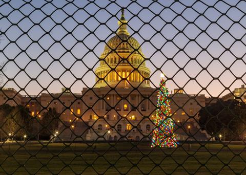 A picture taken during the sunrise over the United States Capitol Building and the Capitol Christmas Tree, now fenced off from the public during the government shutdown. 