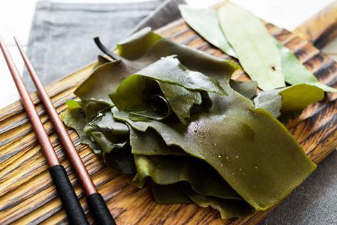 Soaked kelp on wooden board with chopsticks