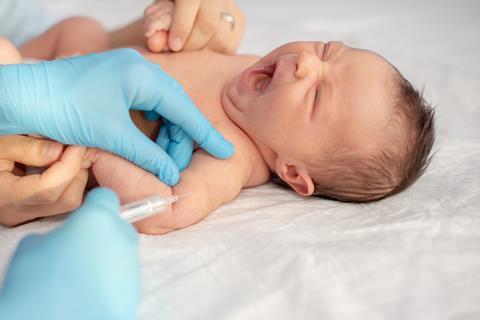 A newborn baby receiving an injection