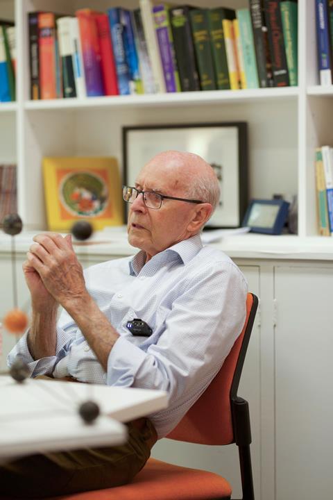 Richard Robson sitting in an office, with a wood and metal chemical model in the foreground