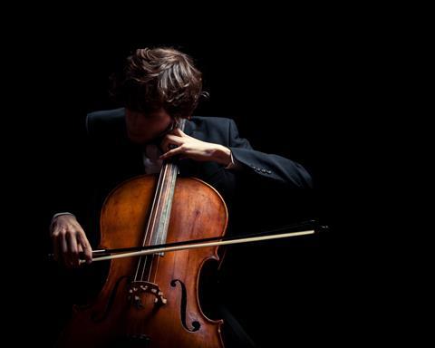 Man playing cello, dark background