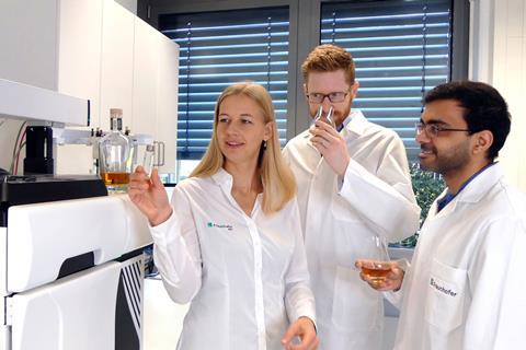 Three scientists in a lab examing whiskies.