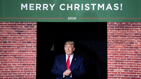 An image showing Donald Trump next to a Merry Christmas sign