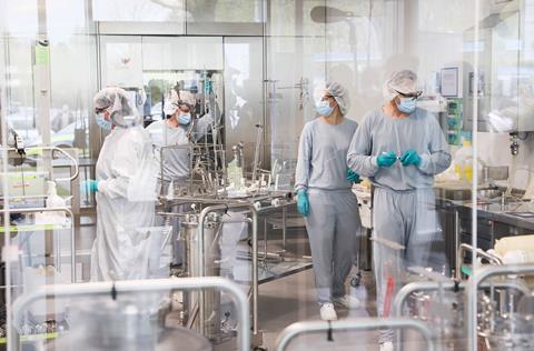 An image showing workers in a cleanroom preparing coronavirus vacine