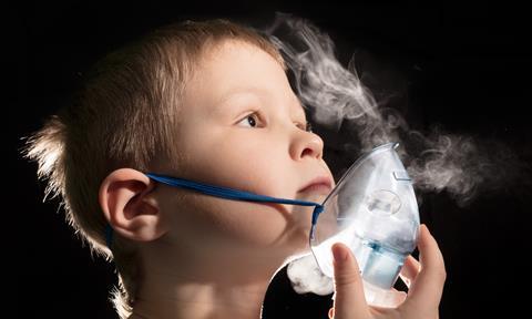 Child inhaling vapour through a nebuliser mask