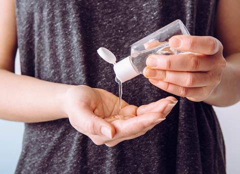 A woman pours hand sanitiser into her palm