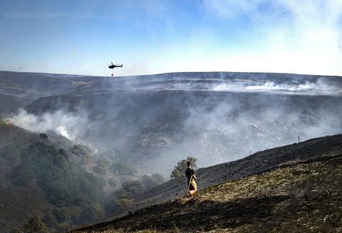 An image showing a firefighter tackling the wildfire on Saddleworth Moor 