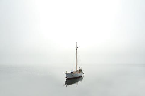 Sailboat in calm but foggy water