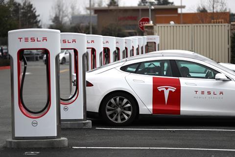 A picture showing a Tesla car and chargers