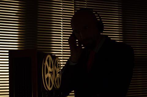 Special agent intelligence officer listens to conversations and records on a reel 