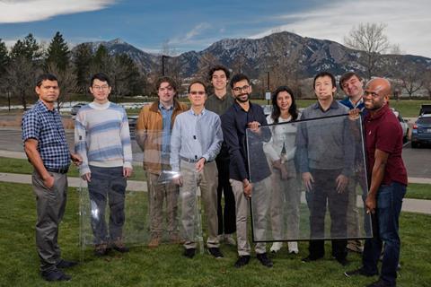 A photograph showing 10 University of Colorado at Boulder researchers holding two large window panes
