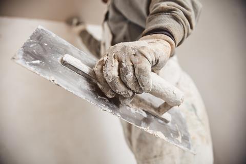 A workman using gypsum plaster