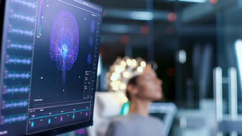 Monitors show EEG reading and brain model