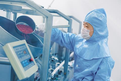 An image showing a pharmaceutical factory worker
