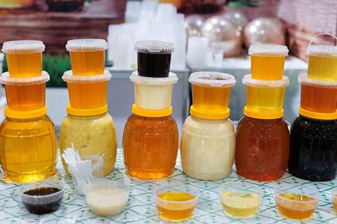 Jars containing a wide variety of honey, from light and dark liquids to very pale, more solid products