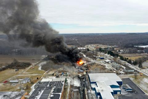Aerial view of a fire from a train derailment with a large plume of black smoke