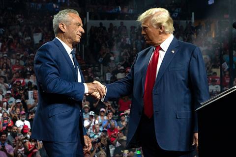 Robert F. Kennedy shaking hands with Donald Trump at a political rally