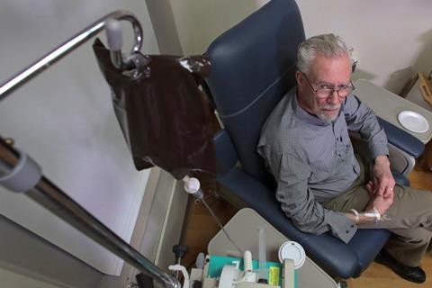 A photo of an elderly man receiving treatment via an IV drip