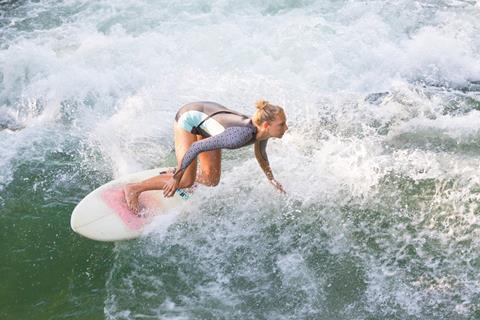 A photograph of a surfer wearing a neoprene wetsuit