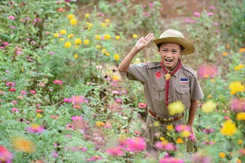 Cub scout surrounded by flowers