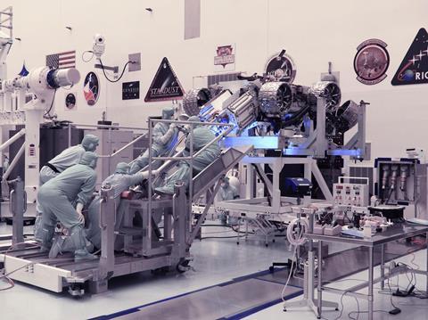 People wearing dust-free suits working on a space project