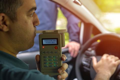 An image showing a driver using a breathalizer 