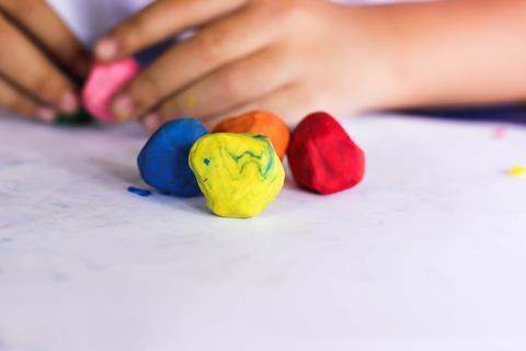 Child playing with colourful potty putty
