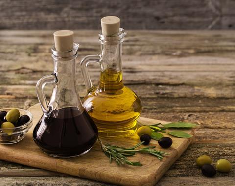 Bottles of olive oil and balsamic vinegar on a wooden table