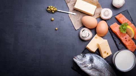 Foods containing vitamin d laid out on a black table 