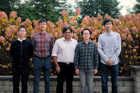 A team shot of five professional men standing outside