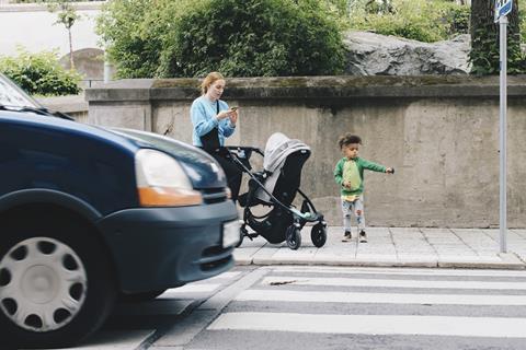 显示一个女人和孩子跨街斑马