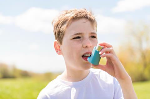 Boy using asthma inhaler