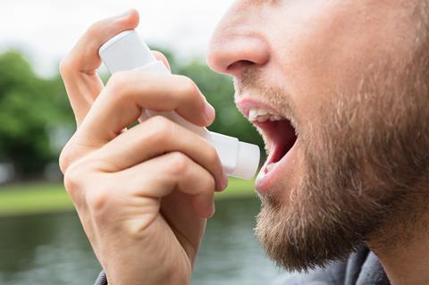 Man using asthma inhaler