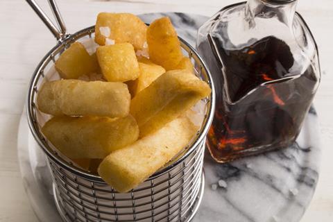 french fries in a serving basket, served with malt vinegar in a bottle