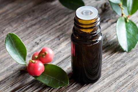 A dark bottle of wintergreen essential oil on old wood