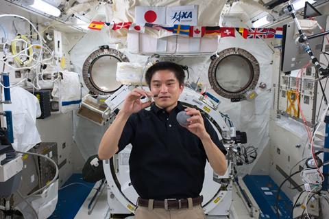 An image showing an astronaut holding a Hayabusa model