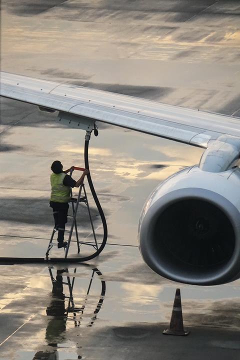 An image showing a man fuelling an airplane