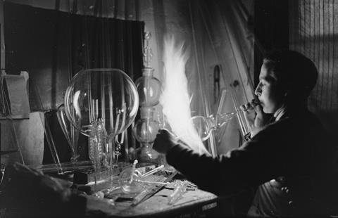 Glass blower forming a chemistry glass, closeup view, glass blower