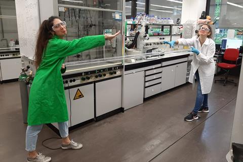 An image showing two socially distance colleagues in a lab