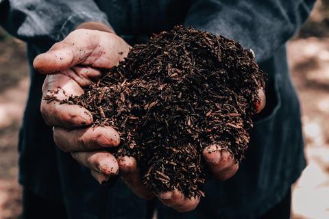 Farmer holding pile of arable soil