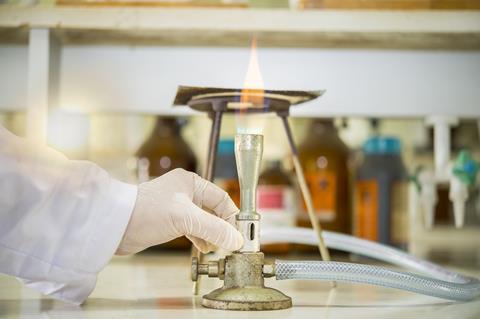 Scientist adjusting the air on the bunsen burner in a lab