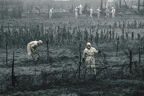 Workers in protective suits cleaning up land