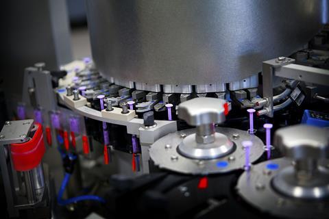 A pharmaceutical factory where syringes are being filled with medication