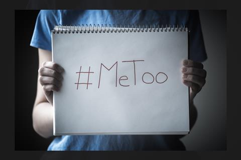 A photo showing a woman holding up a me too sign