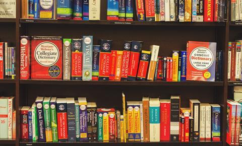 Photo of english language dictionary books on bookshelves in booksellers shop 