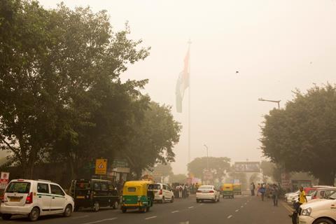 New Delhi, India, November 08, 2017: People driving on a fog coverd road in a busy afternoonn at central city area of New Delhi