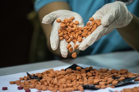 A Bureau of Customs (BOC) personnel displays confiscated ecstasy at a press conference in Manila on September 14, 2016