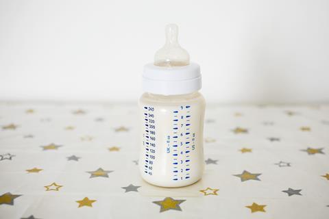 A baby bottle full of milk on a tabletop